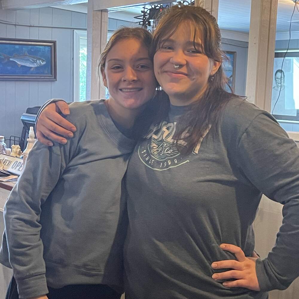 Two smiling team members in the dining room at The Point Restaurant Perdido