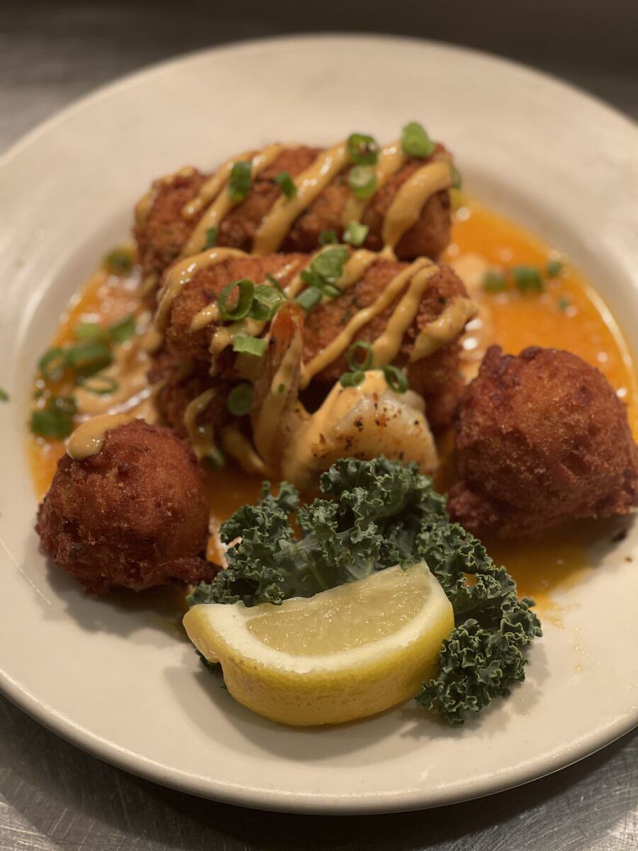 Fried crab cakes and hush puppies plated at The Point Restaurant Perdido