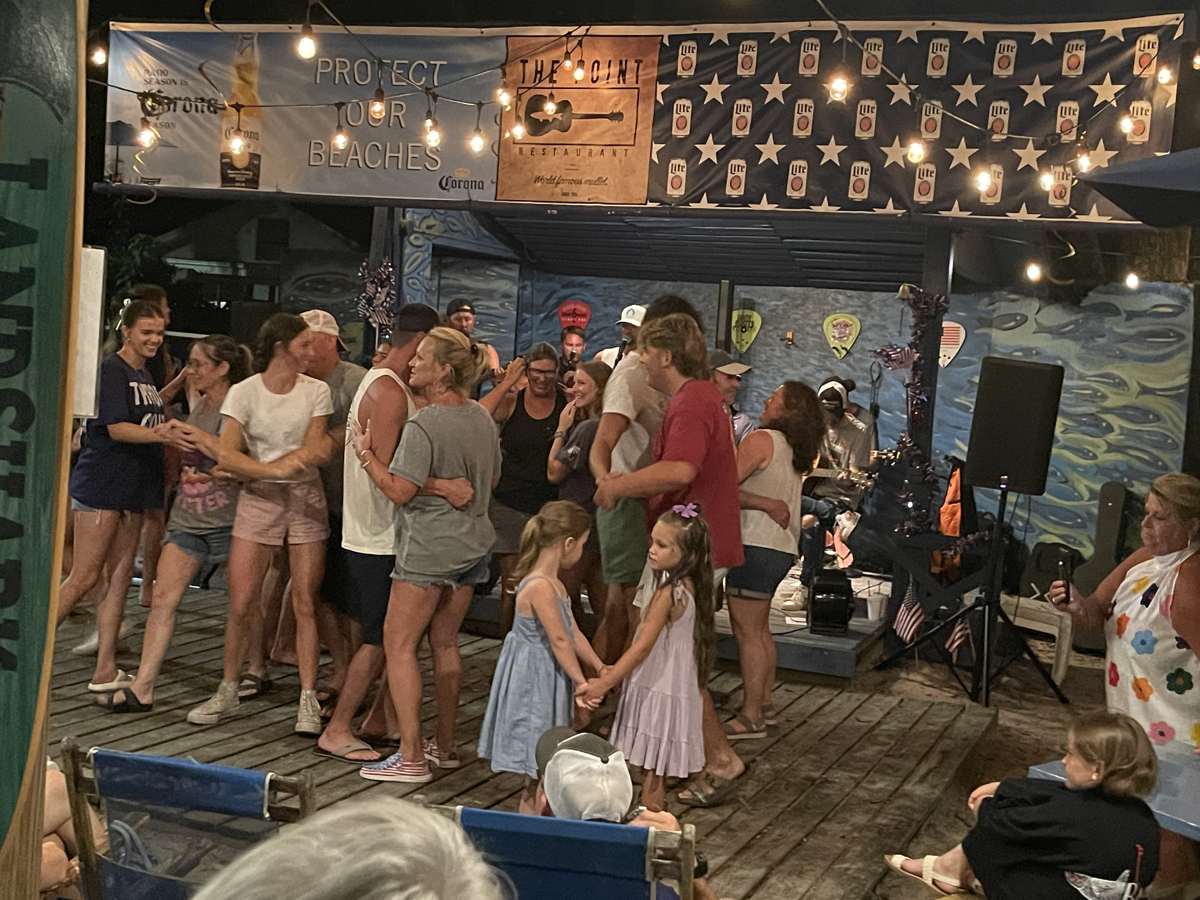 Families dancing to live music at night in The Courtyard at The Point Restaurant Perdido