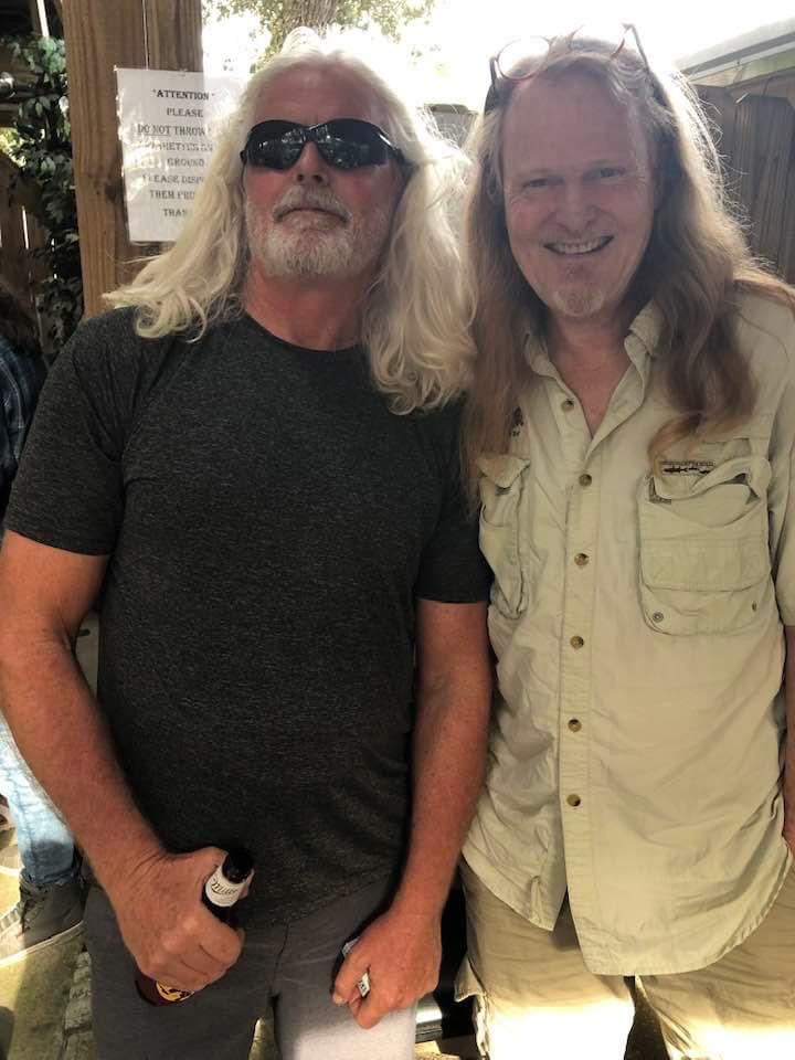 Two longtime friends posing outside The Courtyard at The Point Restaurant Perdido